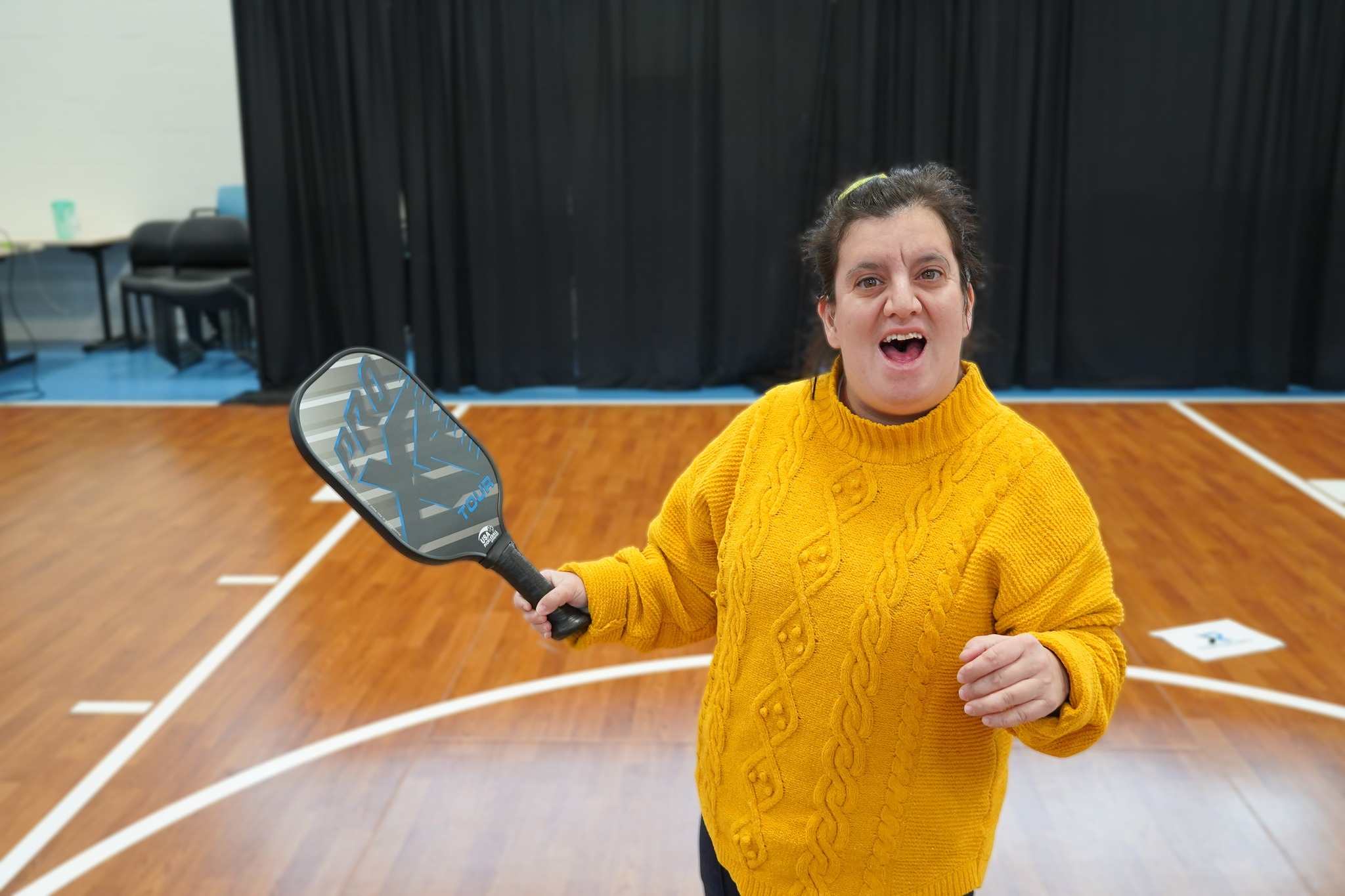 A picture of CEL member playing pickleball in gym.
