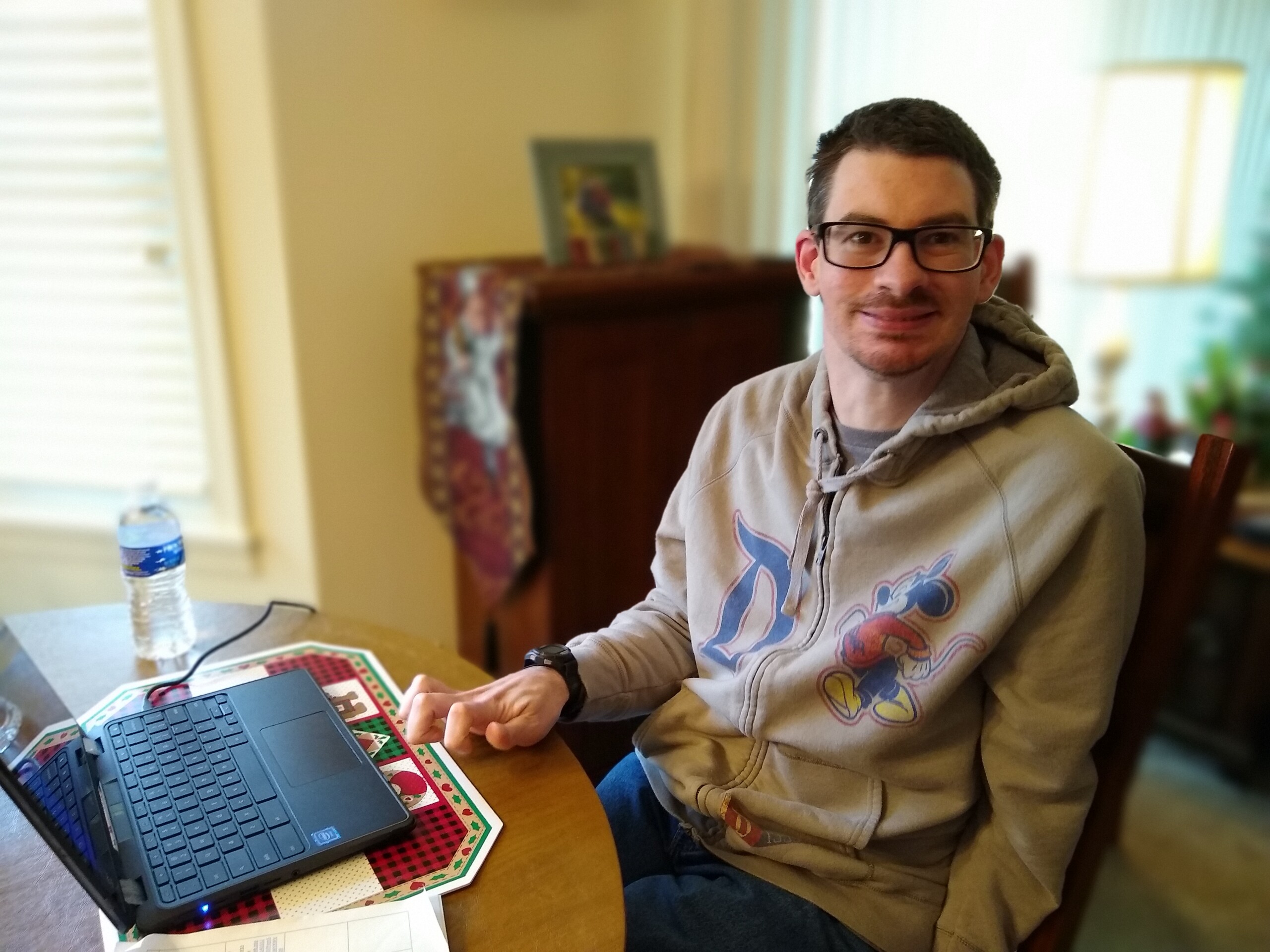 A photo of CEL member Billy with laptop smiling ready for virtual programs.
