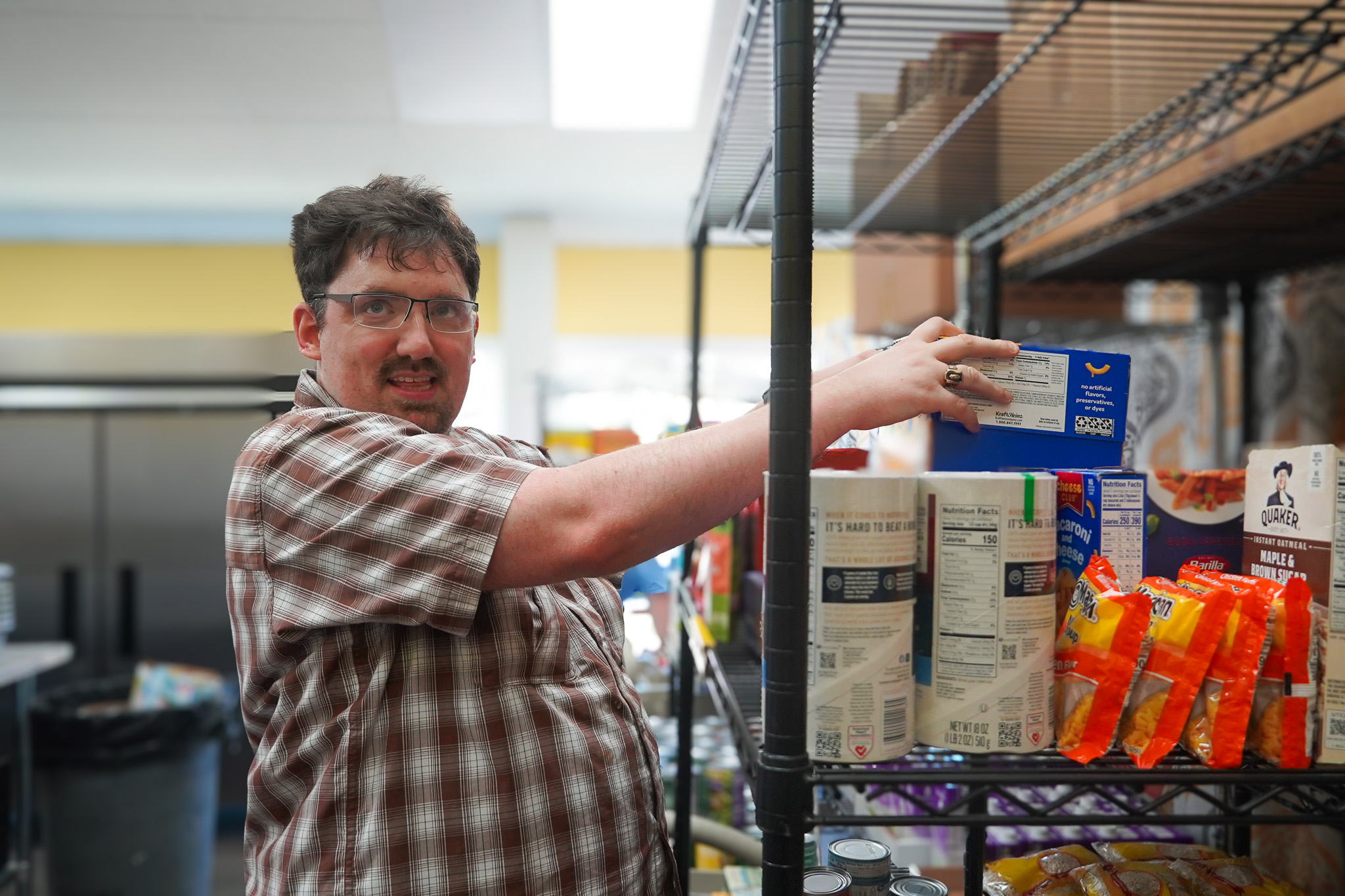 Catalyst Life Skills Program member volunteering at community event helping to stock food items.