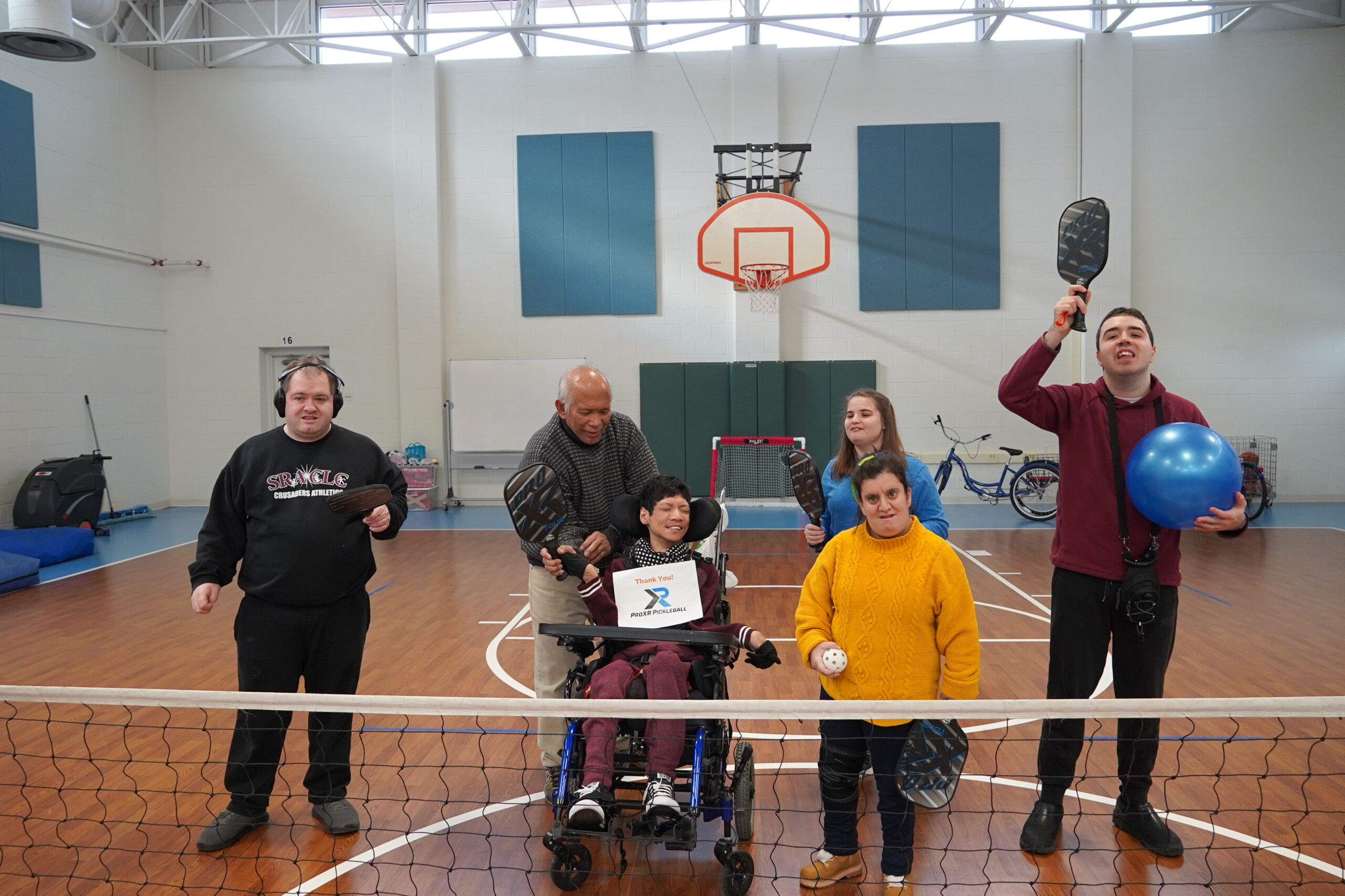 A group photo of CEL members with pickleball rackets.