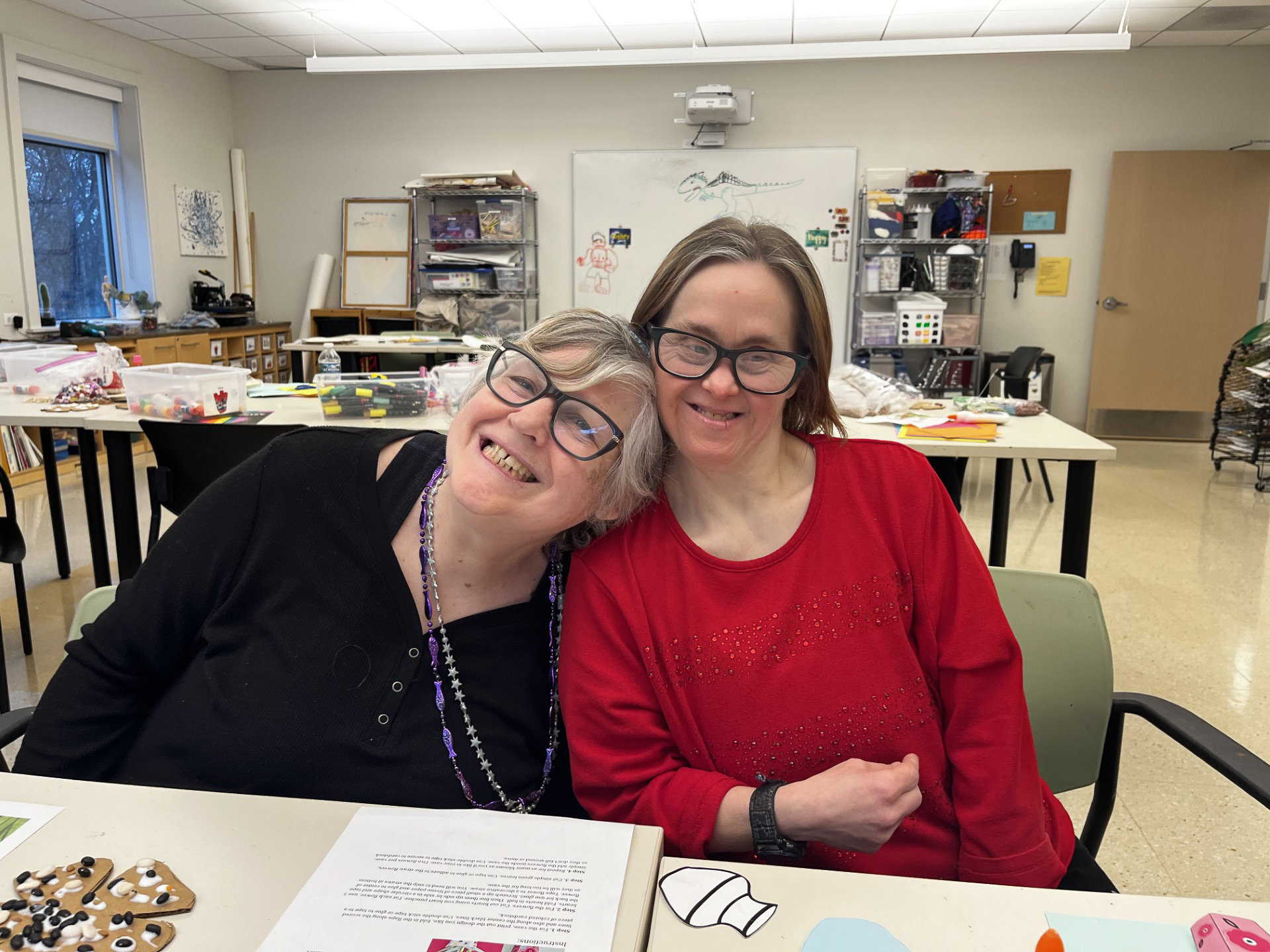 Two members smile and sit next to each other