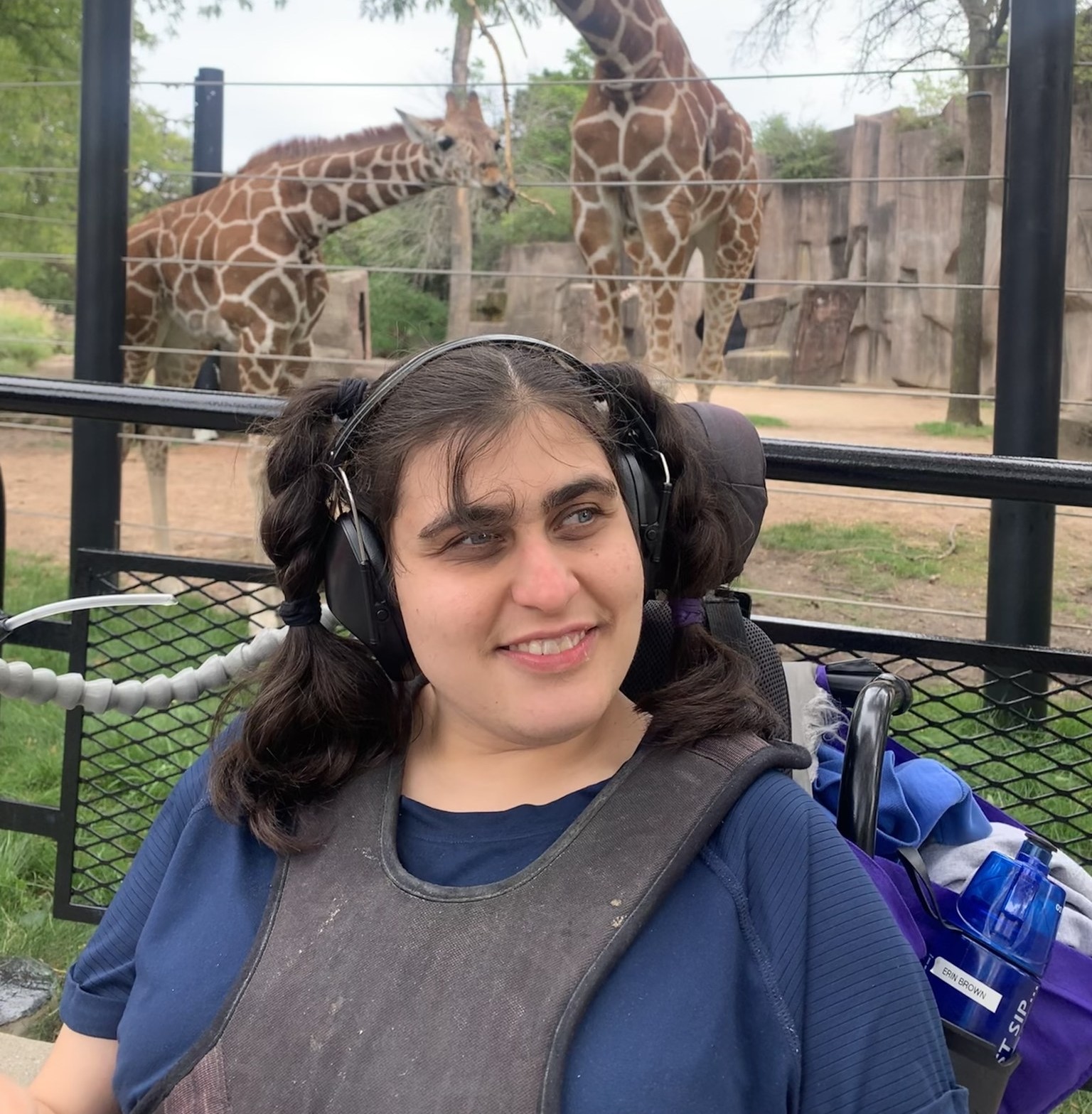 A CEL member at the Milwaukee Zoo smiling with giraffes.