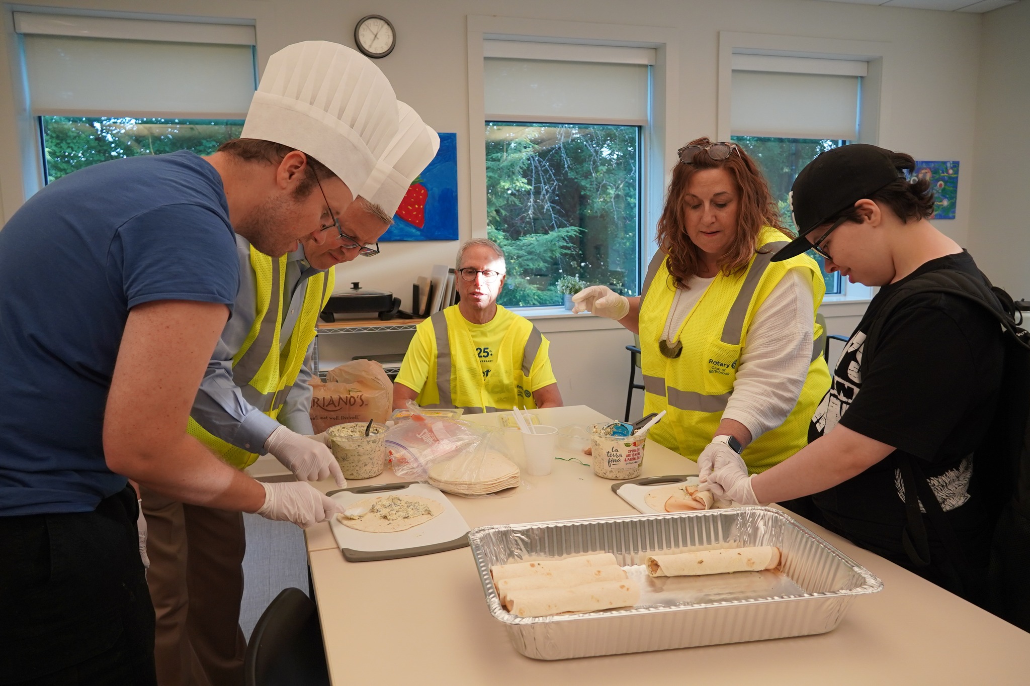 A photo of Thursday Guy's Night members making sandwiches during Rotary activity.