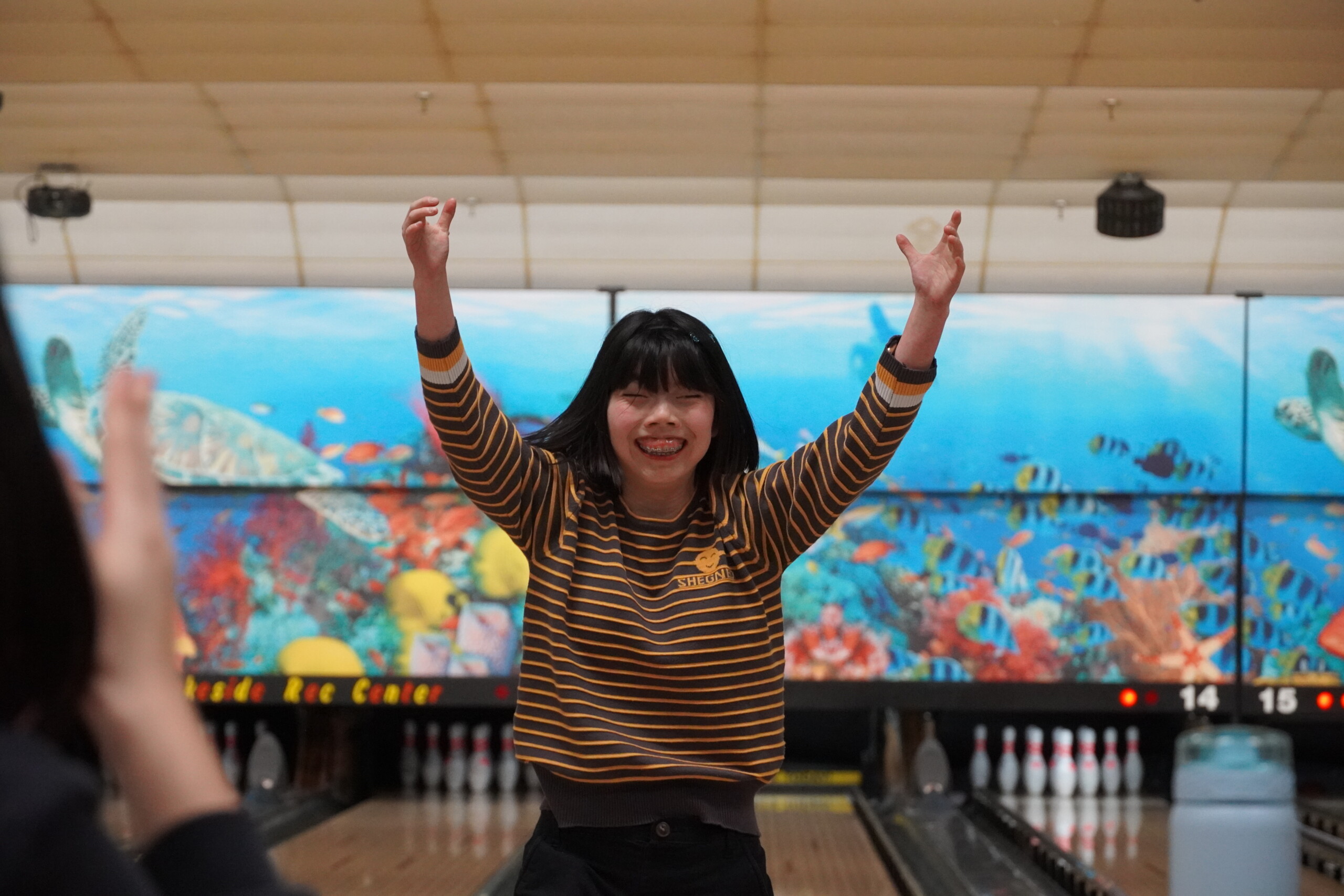 CEL member proudly smiling after a strike at Monday Night Bowling.