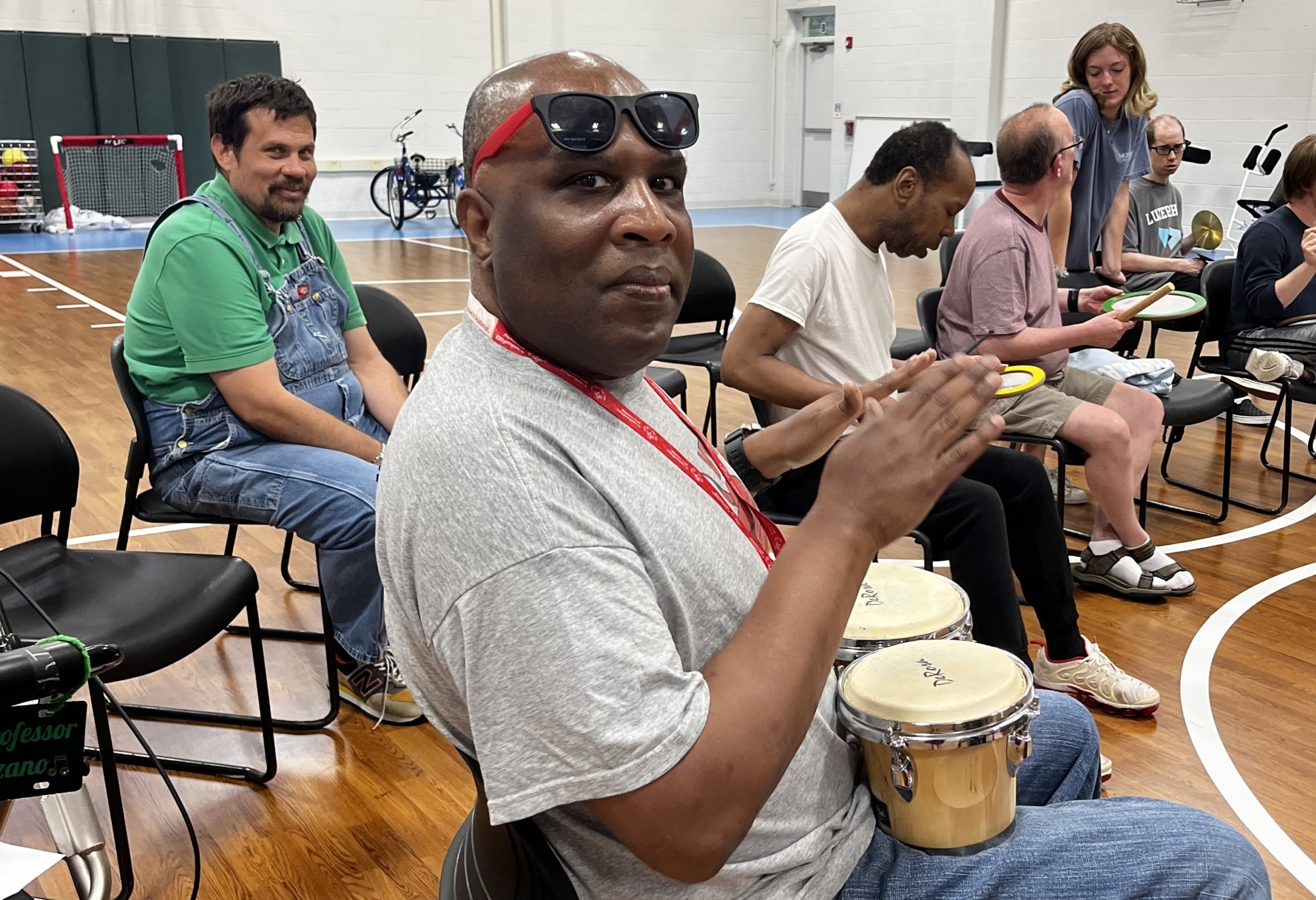 CEL member Darryl smiling while playing the drums during Friday Night Music with his CEL friends.