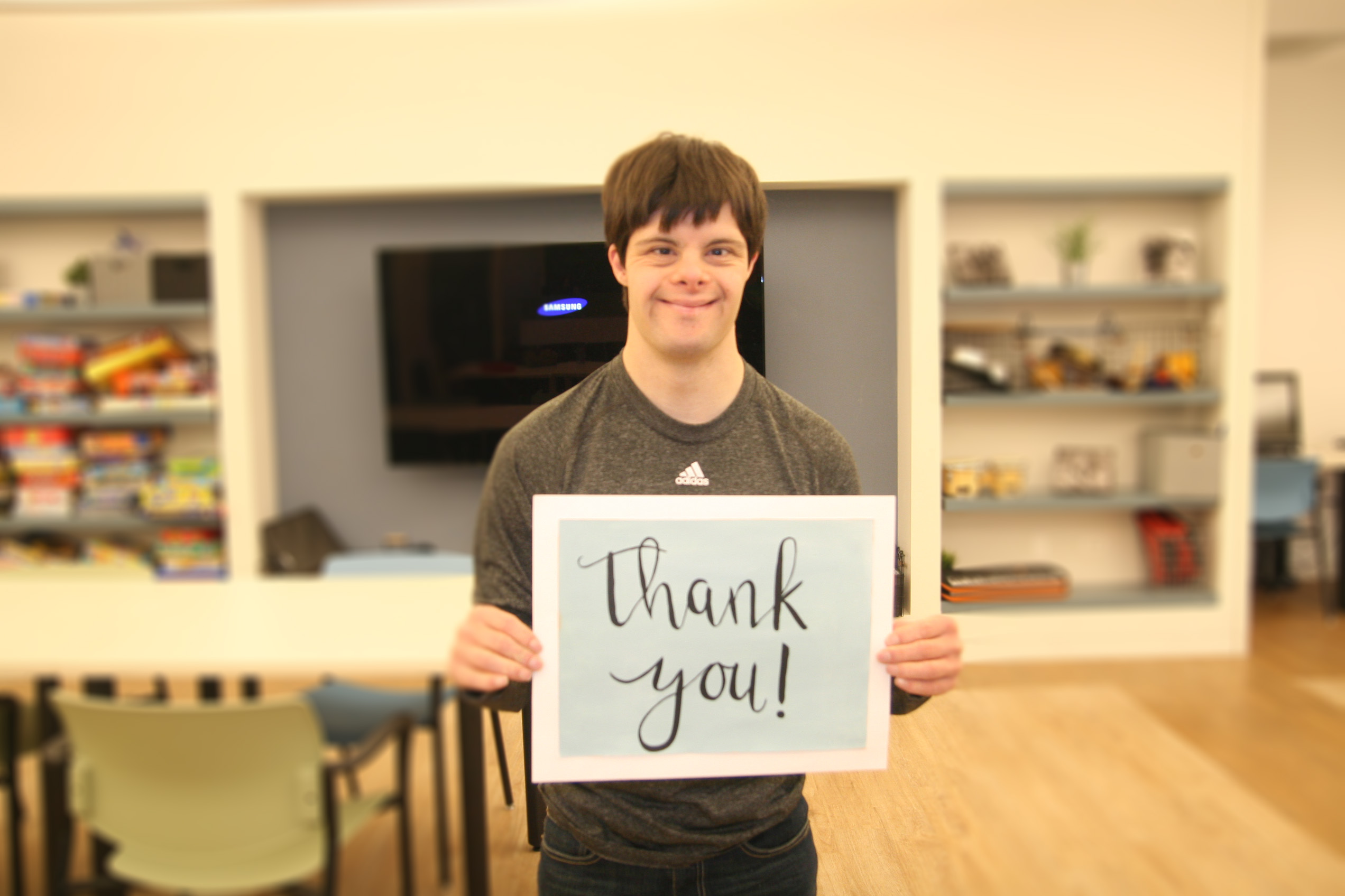 A picture of CEL member Matt smiling while holding a graphic that says,