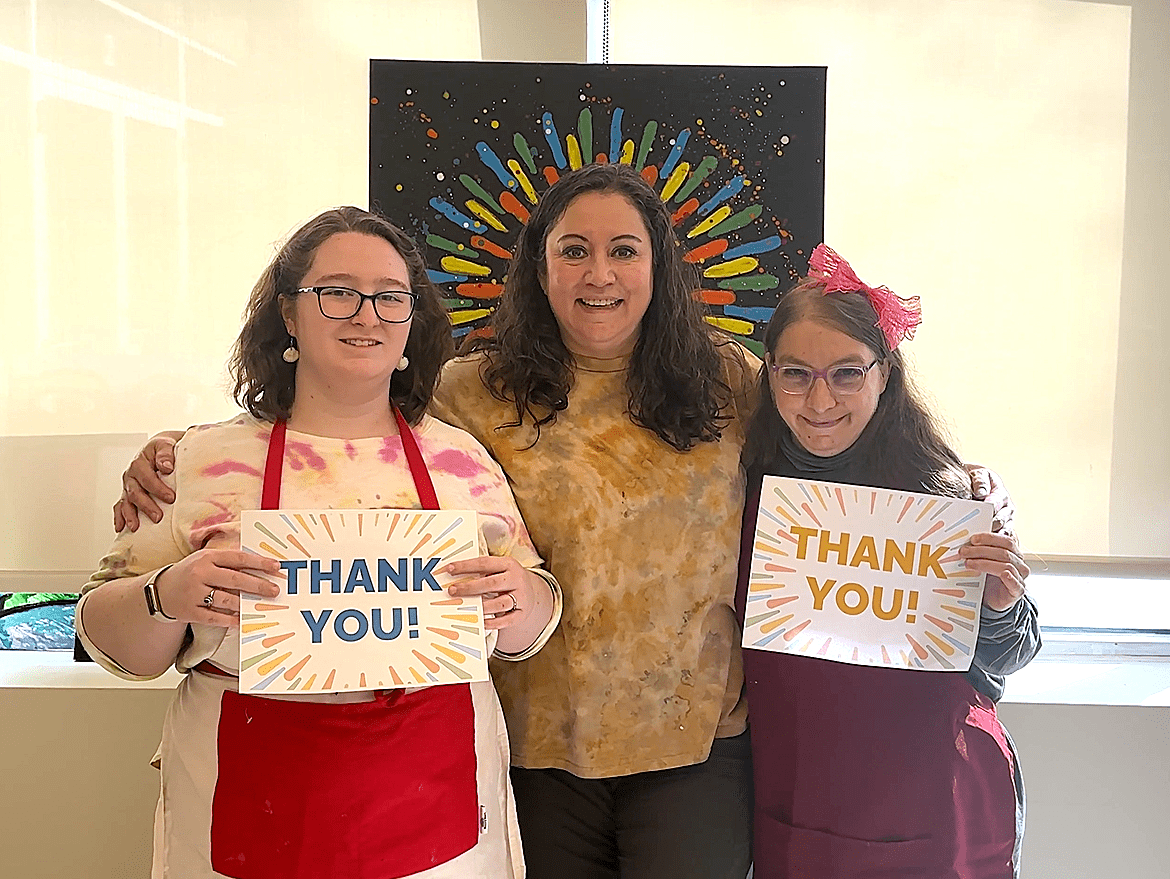 A photo of CEL members holding thank you sign with staff.
