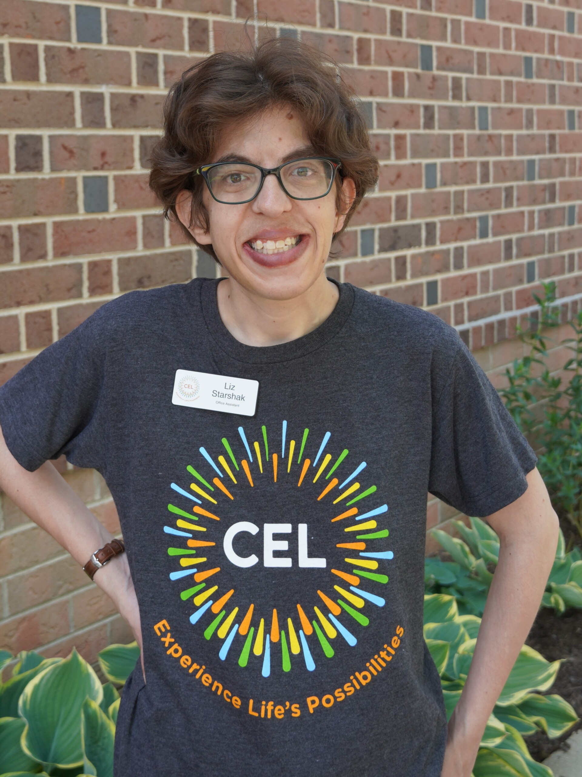 CEL Staff Liz, S smiling wearing CEL merch at community day.