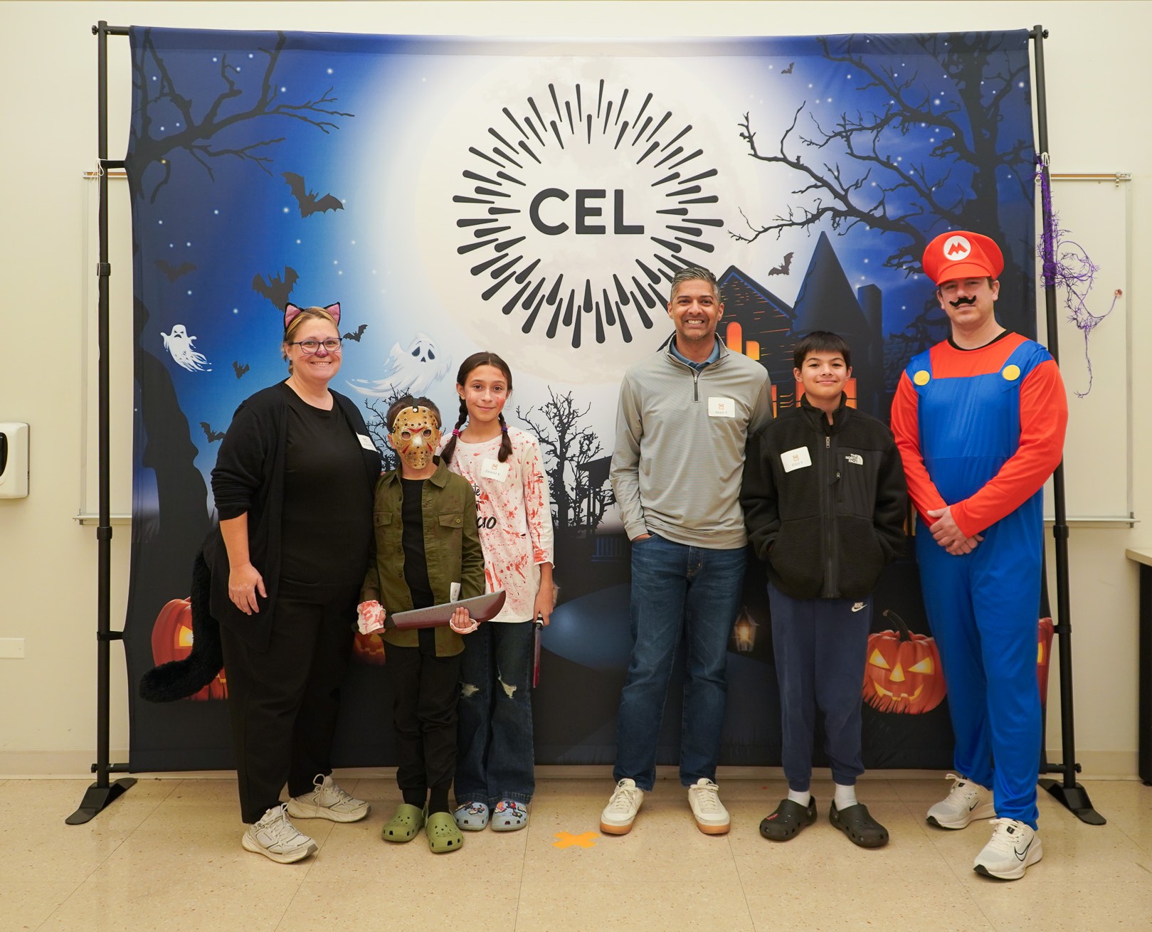 CEL members and volunteers in costume pose in front of the Harvest Dance