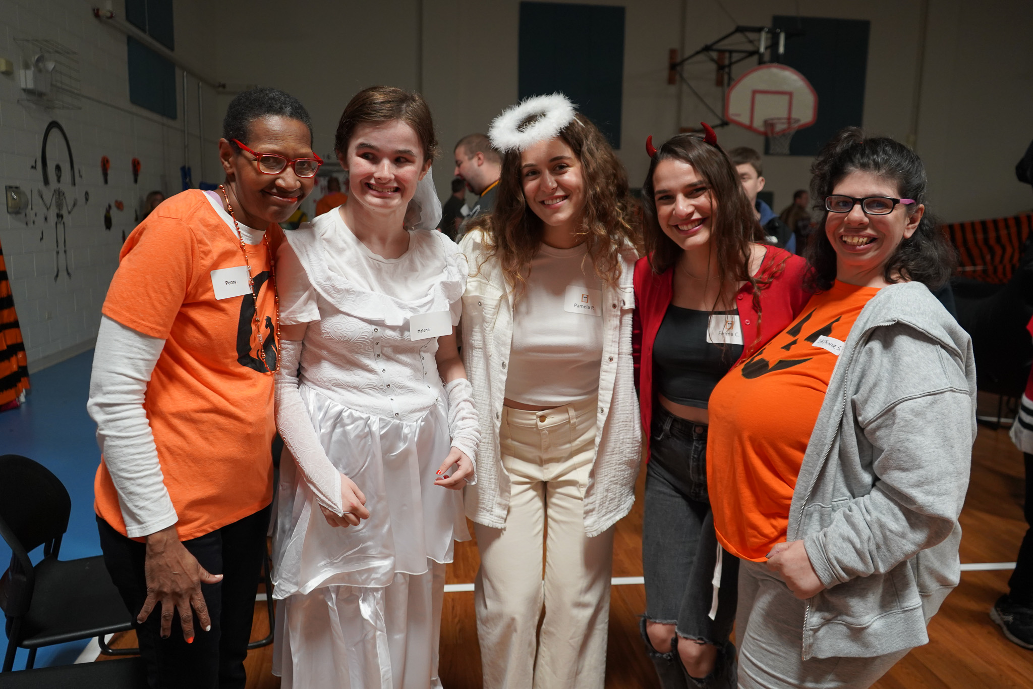 5 members and volunteers pose in costumes at the Harvest Dance