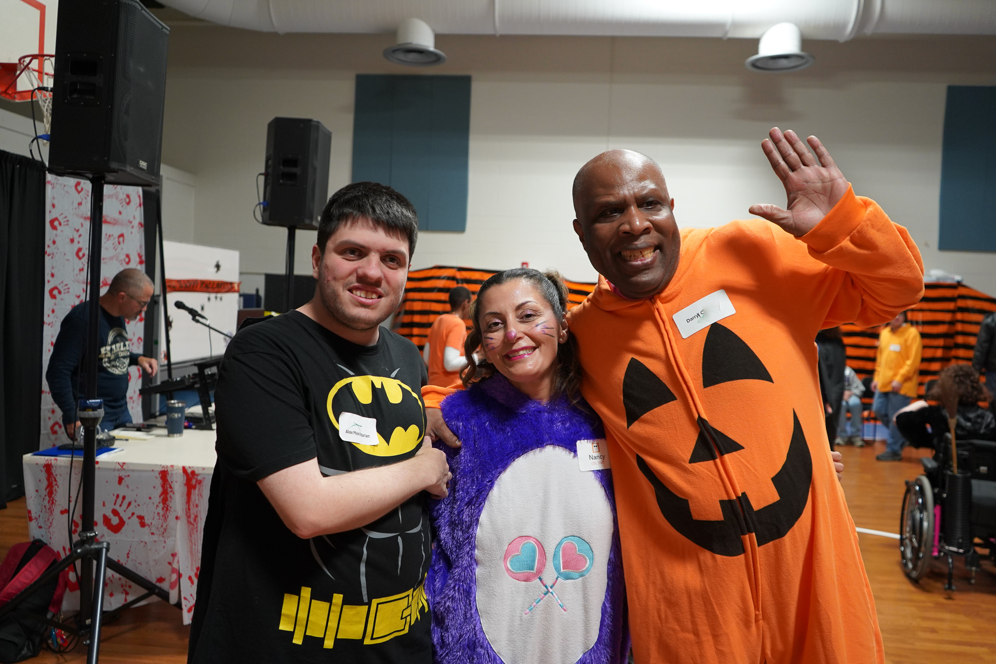 Members pose in pumpkin, Care Bear, and Batman halloween costumes at the Harvest Dance