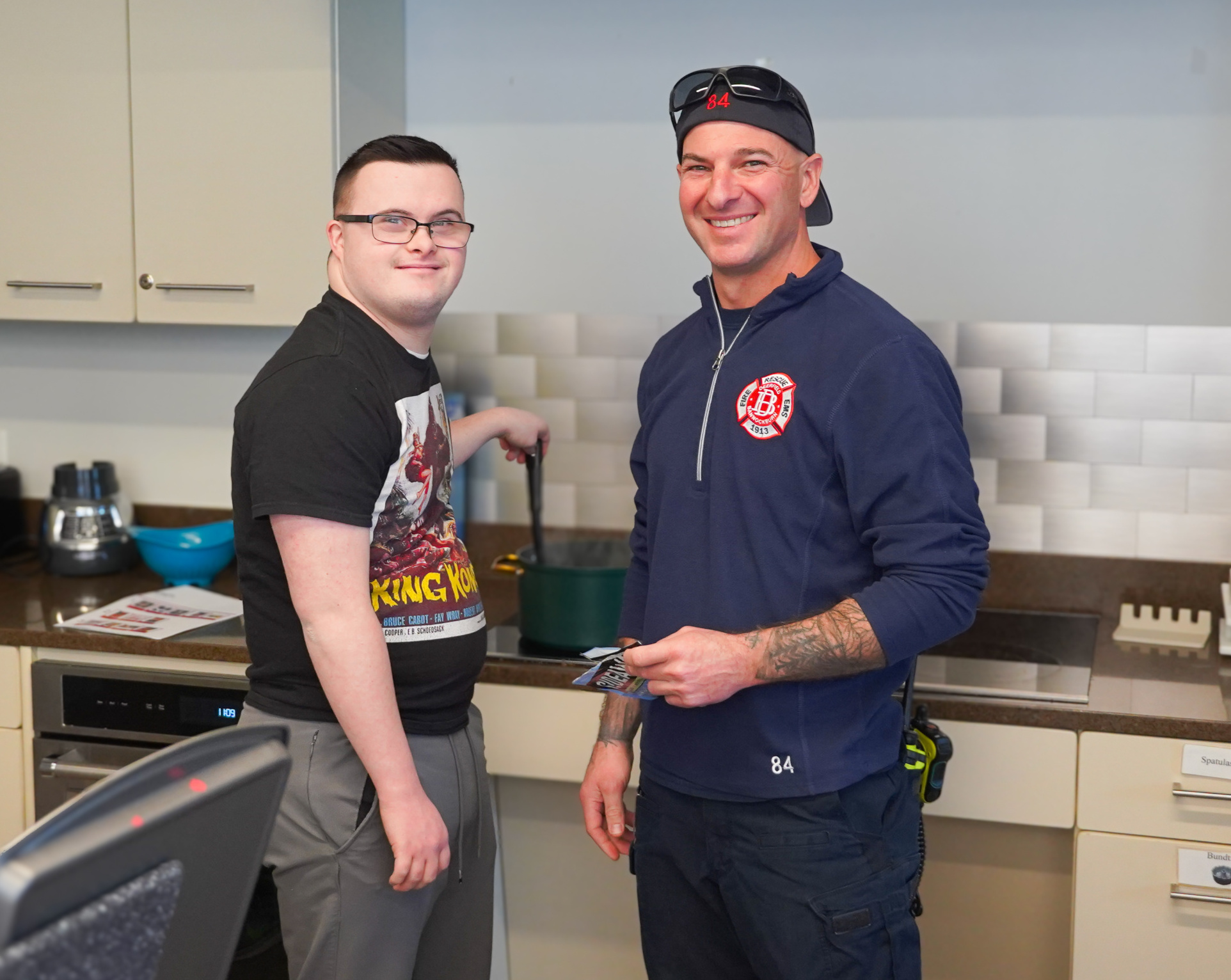 A member and staff smile in the kitchen