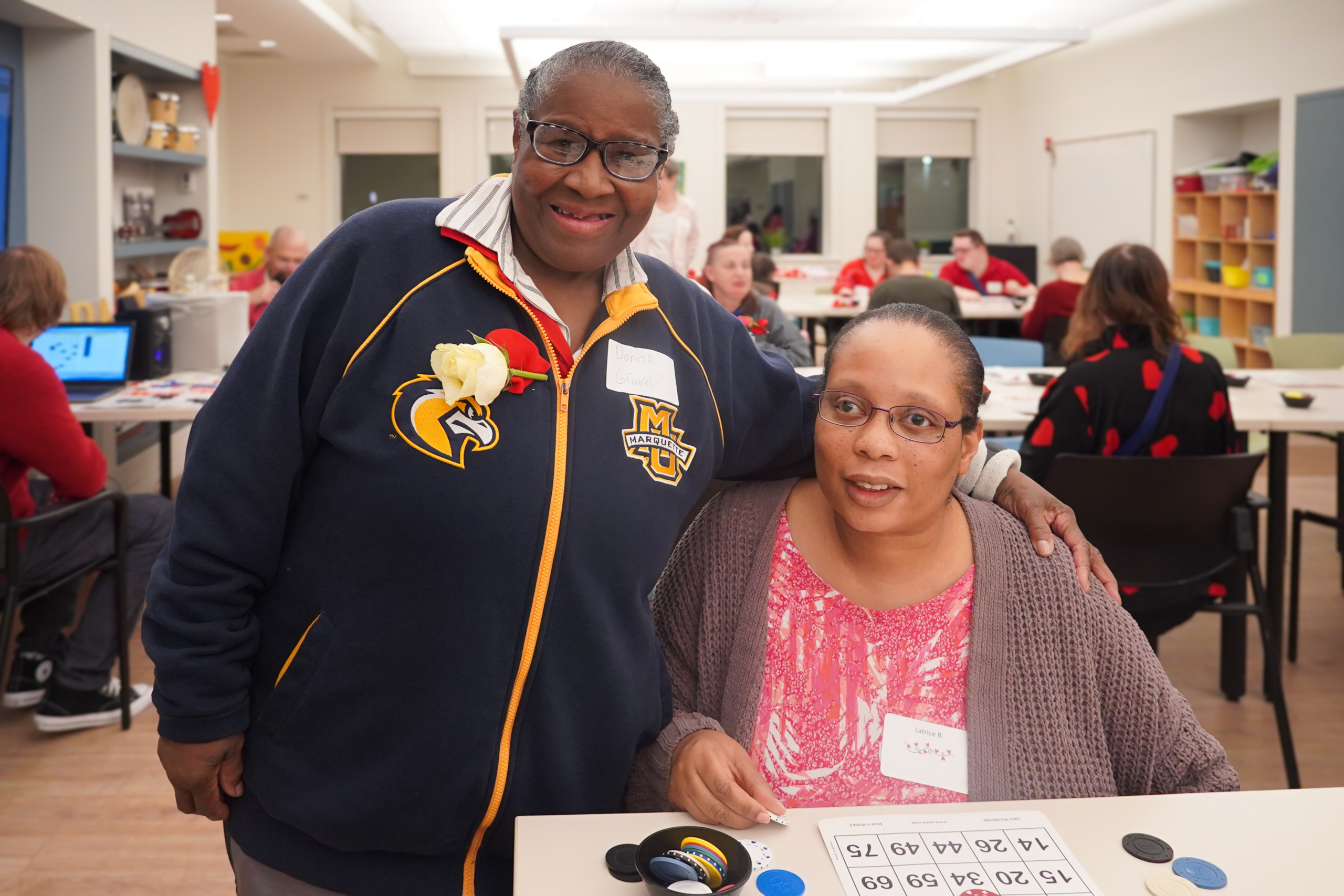 Two members pose for a photo during bingo