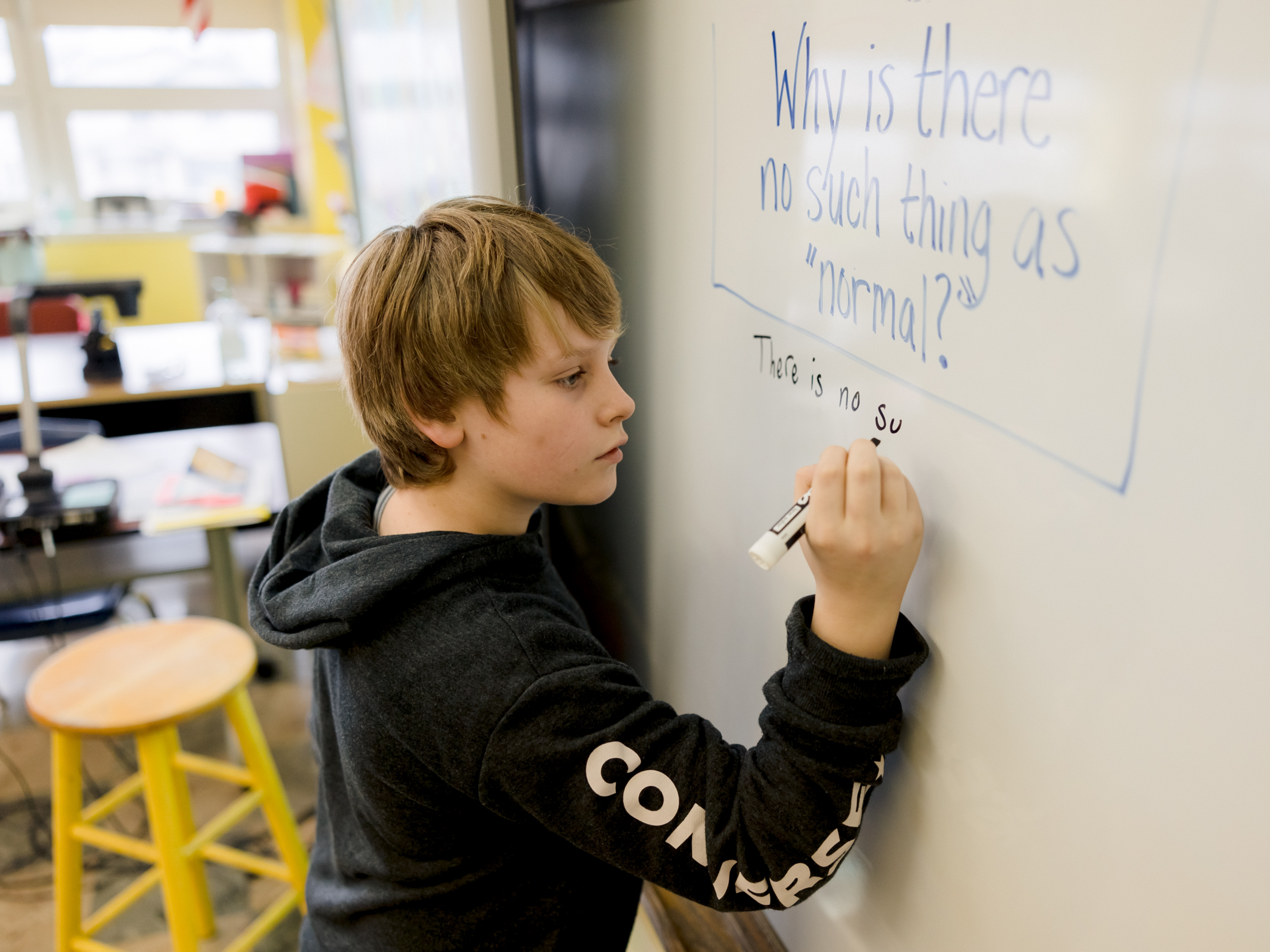 student writes on a whiteboard