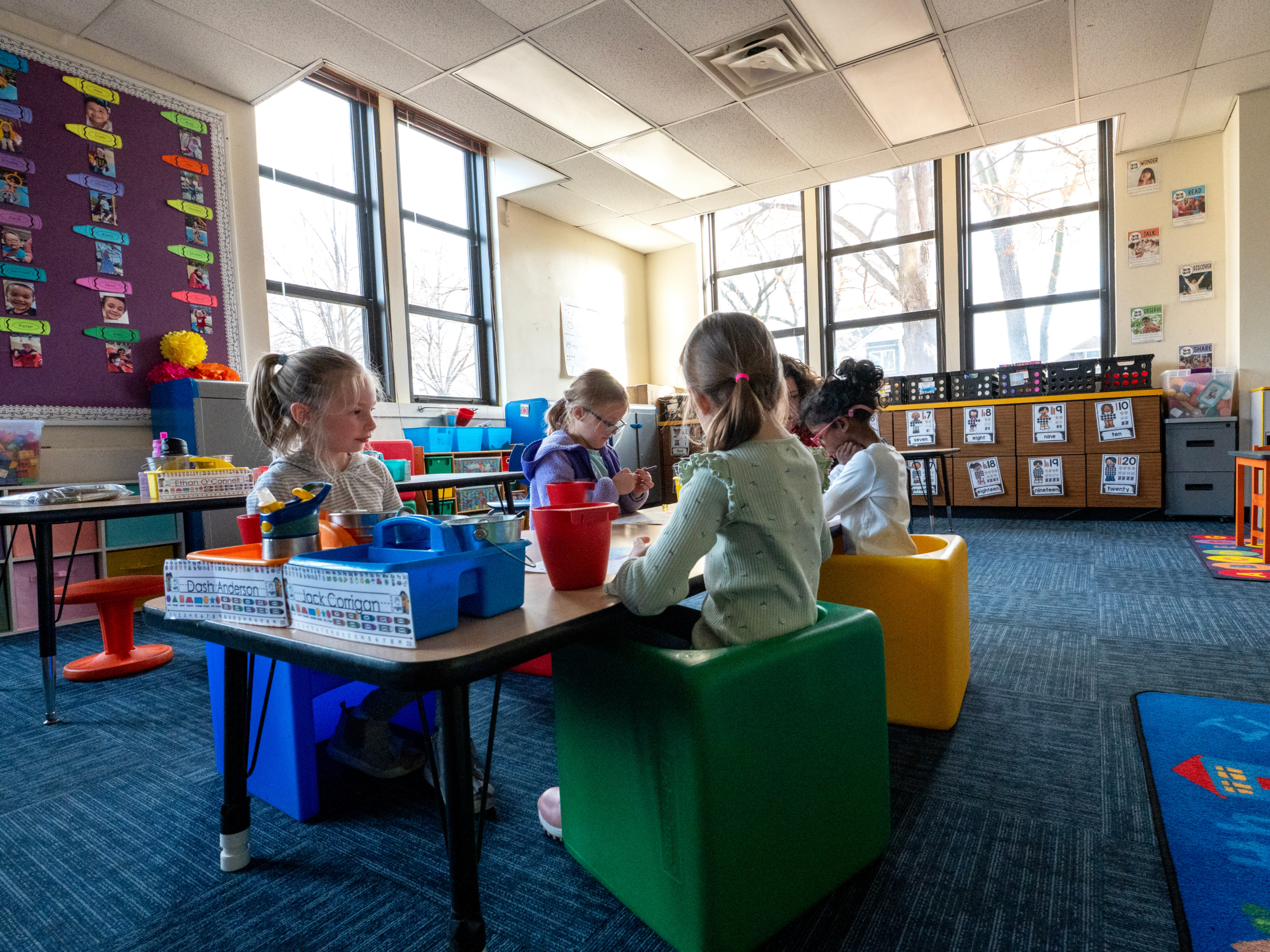 four young students sit in a classroom