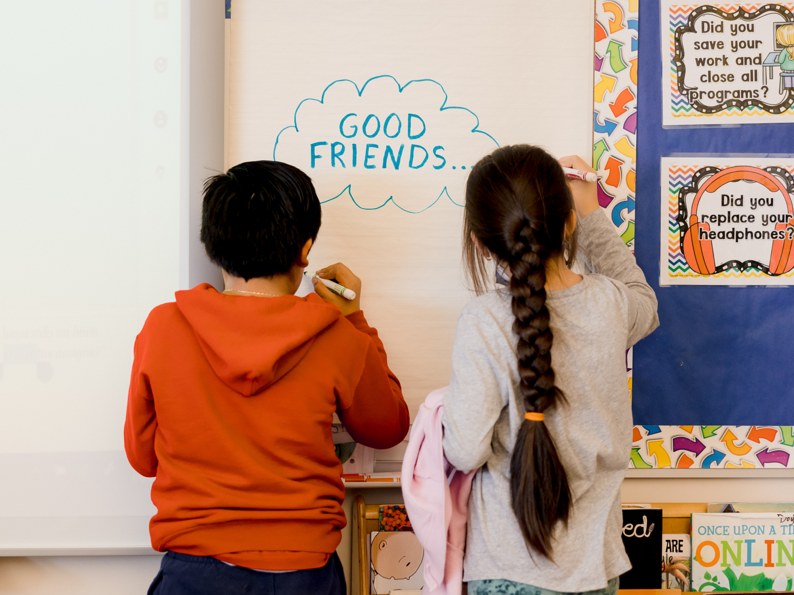 two students write on a white board